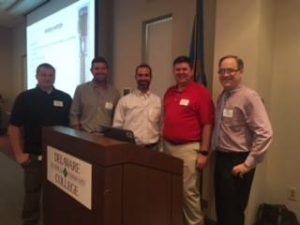 Steven Brown team standing by a podium